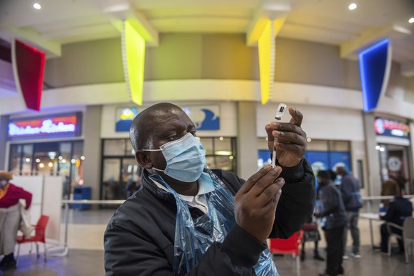 FILE - In this July 6, 2021, file photo, a health worker prepares a vaccine against COVID-19 in Hammanskraal, South Africa. New infections in South Africa rose to record levels in recent days, part of ...