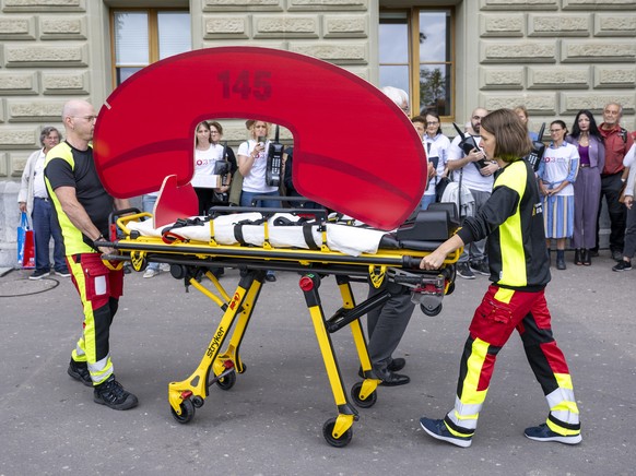 KEYPIX - Zwei Personen transportieren auf einer Bahre eine Notrufnummer, sowie weitere Personen ueberreichen die Giftnotruf-Petition mit 100'000 Unterschriften, am Mittwoch, 10. September 2025, i ...