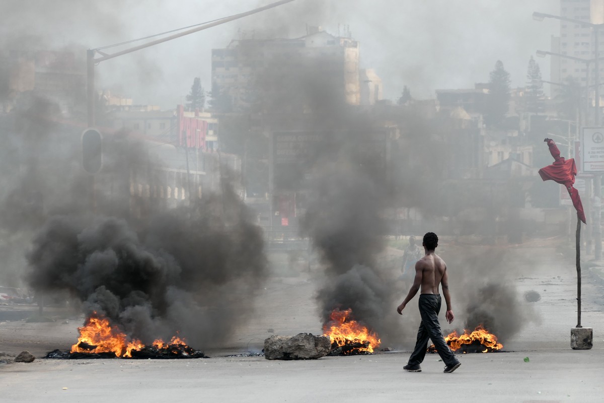 epaselect epa11791179 A man walks next to a burning barricade during a protest after the Constitutional Council proclaimed Daniel Chapo as the winner of the presidential election with 65.17% of the vo ...