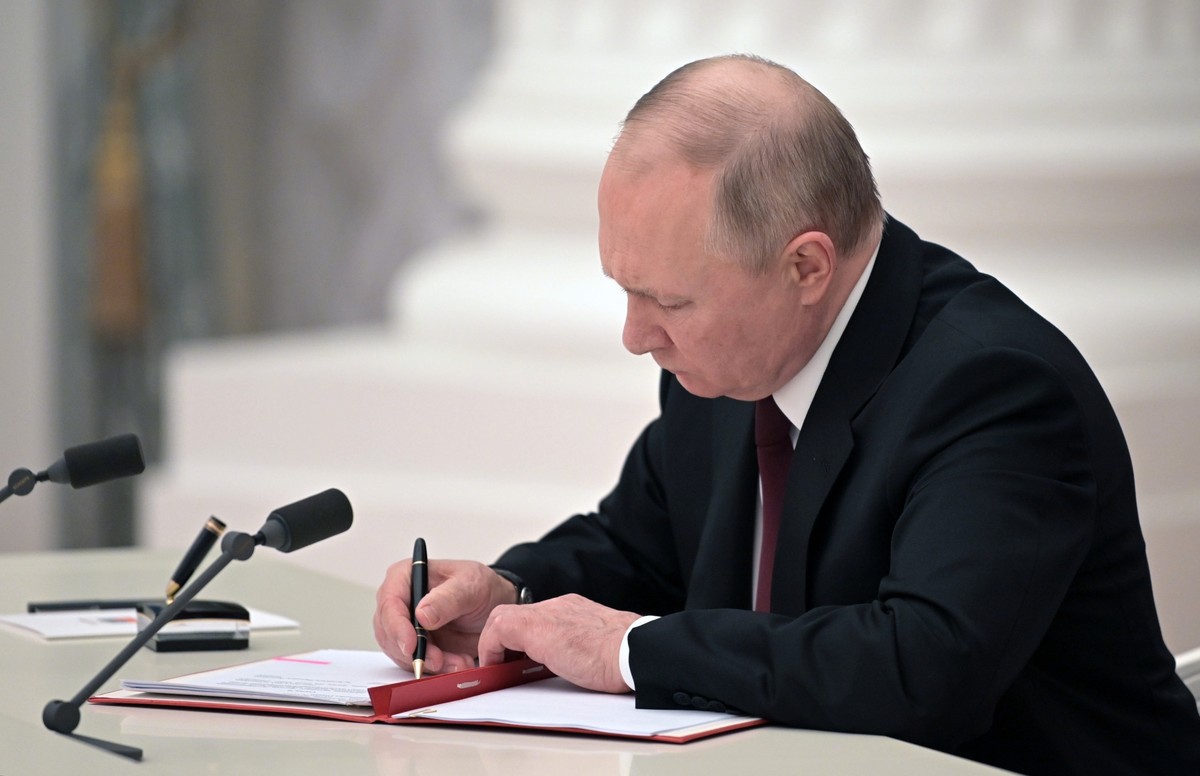 Russian President Vladimir Putin signs a document recognizing the independence of separatist regions in eastern Ukraine in the Kremlin in Moscow, Russia, Monday, Feb. 21, 2022. Russia's Putin has ...
