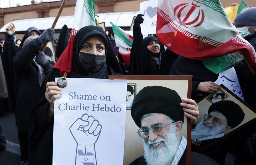 epa10395737 Iranian women hold photos of Iran's Supreme Leader Ayatollah Ali Khamenei during a protest demonstration against France in front of the French Embassy in Tehran, Iran, January 08, 2023. Ir...