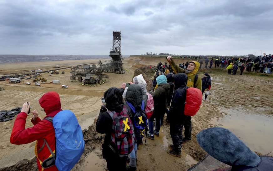 People take pictures as they attend a protest rally at the Garzweiler opencast mining near the village Luetzerath in Erkelenz, Germany, Saturday, Jan. 14, 2023. Swedish climate campaigner Greta Thunbe ...