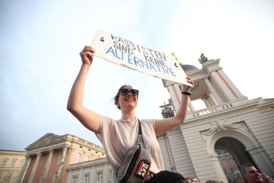 epa07810936 Anti AfD (Alternative fuer Deutschland) protester holds a placard reading 'Racism is not an Alternative' during the Brandenburg state elections in Potsdam, Germany, 01 September 2019. Acco ...