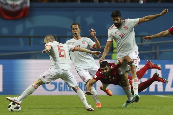 Iran&#039;s Vahid Amiri, center, vies for the ball with Spain&#039;s Andres Iniesta, left, and Spain&#039;s Diego Costa, right, during the group B match between Iran and Spain at the 2018 soccer World ...