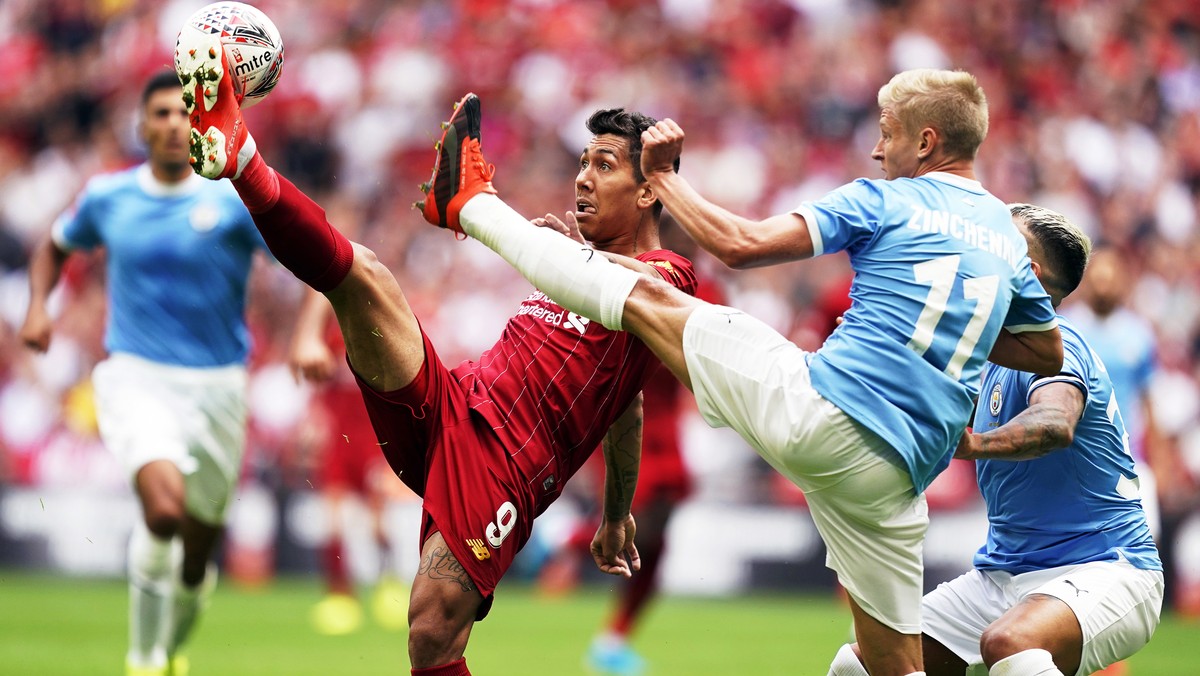 epa07756401 Liverpool's Roberto Firmino (L) in action against Manchester City's Oleksandr Zinchenko (2-R) during the FA Community Shield soccer match between Liverpool FC and and Manchester  ...