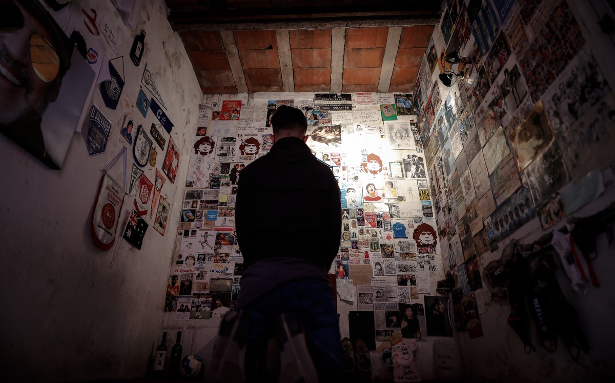 epa09600633 A person stand in a shrine in tribute to the late Argentine former soccer player Diego Armando Maradona ahead of the first anniversary of his death in Buenos Aires, Argentina, 23 November  ...