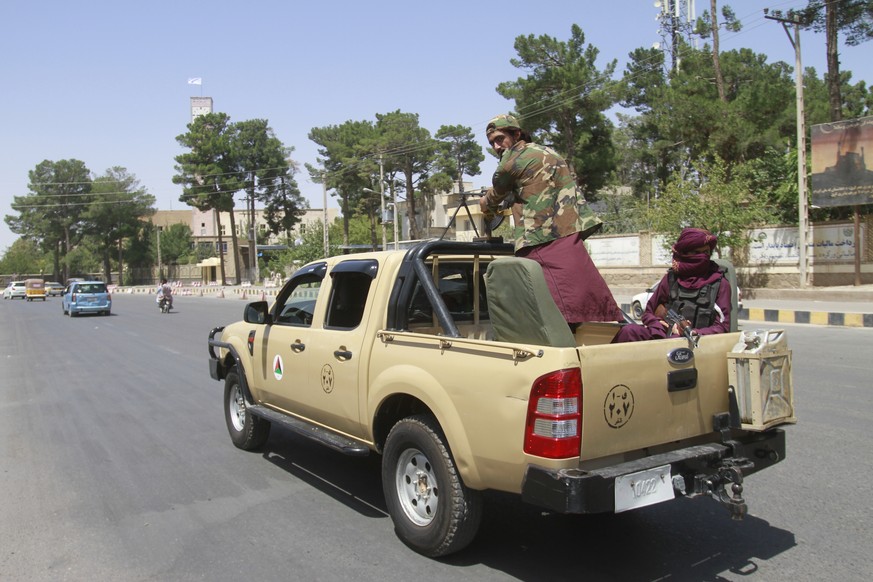 Taliban fighters sit on the back of a vehicle in the city of Herat, west of Kabul, Afghanistan, Saturday, Aug. 14, 2021, after they took this province from Afghan government. The Taliban seized two mo ...