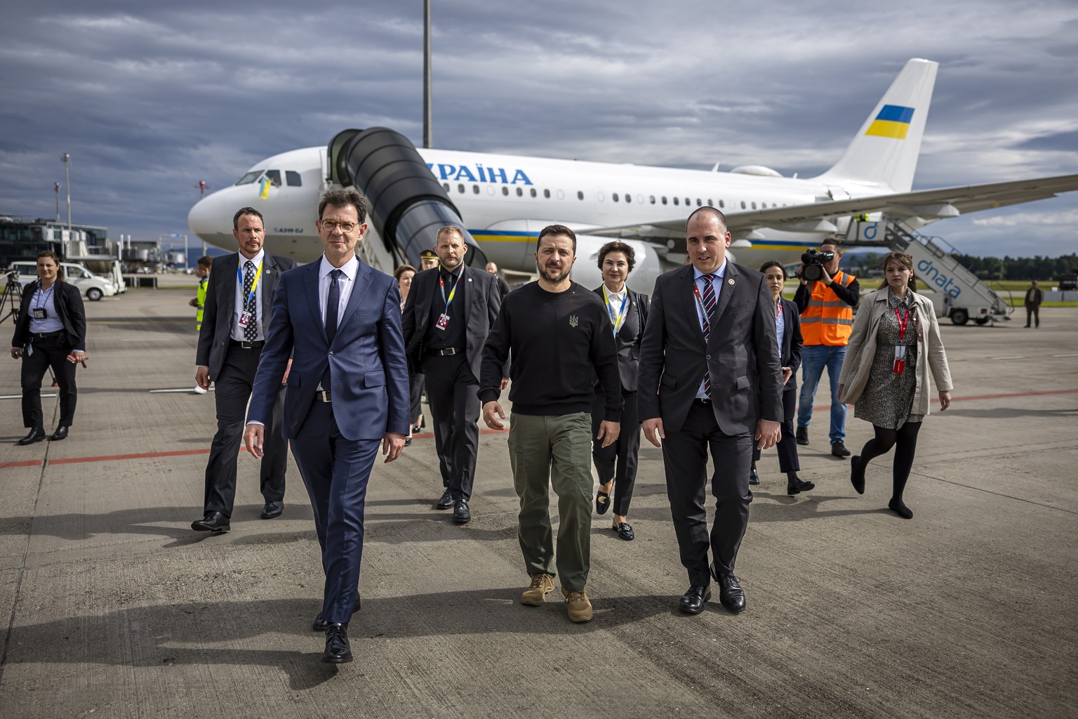 epa11410126 Ukrainian President Volodymyr Zelensky (C) is accompanied upon his arrival by Felix Baumann (L), Ambassador of Switzerland to Ukraine, Iryna Wenediktowa (2-R), Ukrainian Ambassador to Swit ...