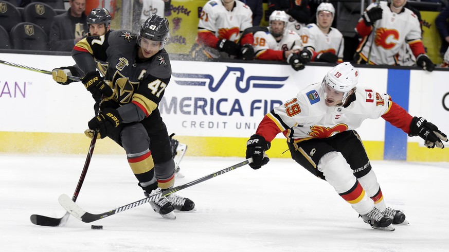 Vegas Golden Knights defenseman Luca Sbisa (47) and Calgary Flames center Matthew Tkachuk reach for the puck during the second period of an NHL hockey game Wednesday, Feb. 21, 2018, in Las Vegas. (AP  ...