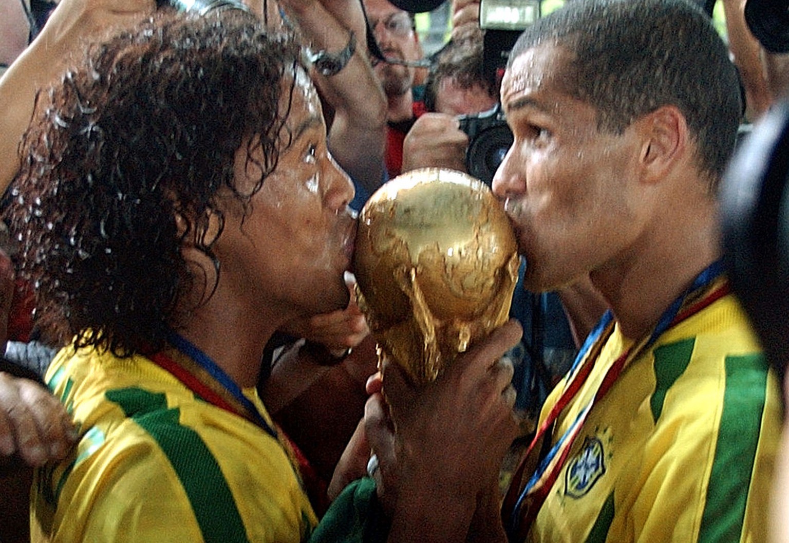 Ronaldinho und Rivaldo küssen den WM-Pokal im Jahr 2002.<br data-editable="remove">