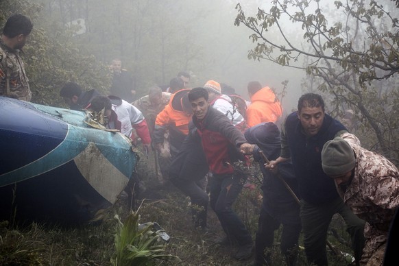 epa11354935 Iranian rescue workers work nearthe wreckage of the crashed Iranian President helicopter, in the area of Varzaghan, Tabriz province, southwestern Iran, 20 May 2024. According to Iranian st ...