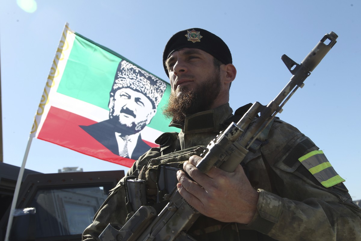 A serviceman listens as Ramzan Kadyrov, leader of the Russian province of Chechnya, speaks to about 10,000 troops in Chechnya's regional capital of Grozny, Russia, Tuesday, March 29, 2022. (AP Ph ...