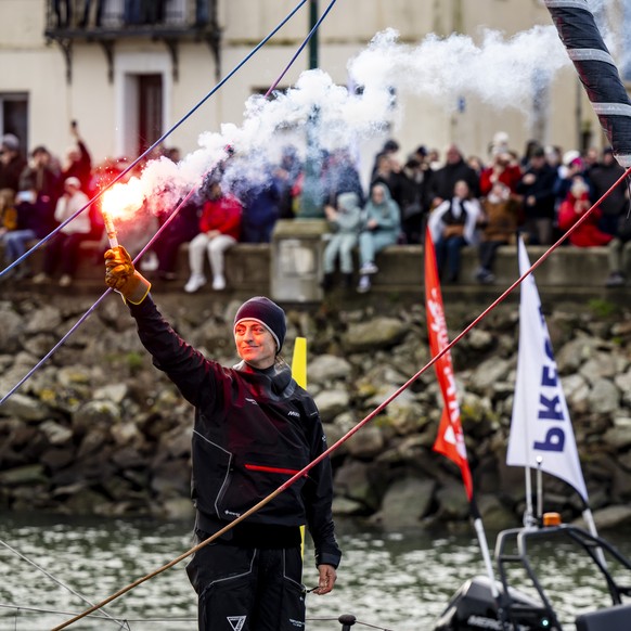 Skipper Justine Mettraux of Switzerland reacts with flairs as she passes through the channel aboard her IMOCA Teamwork-Team Snef after crossing the finish line during the Vendee Globe round-the-world  ...