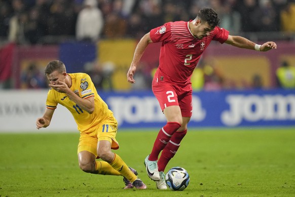 Romania&#039;s Nicusor Bancu falls after a contact with Switzerland&#039;s Filip Ugrinic during the Euro 2024, group I, qualifying soccer match between Romania and Switzerland at the National Arena st ...