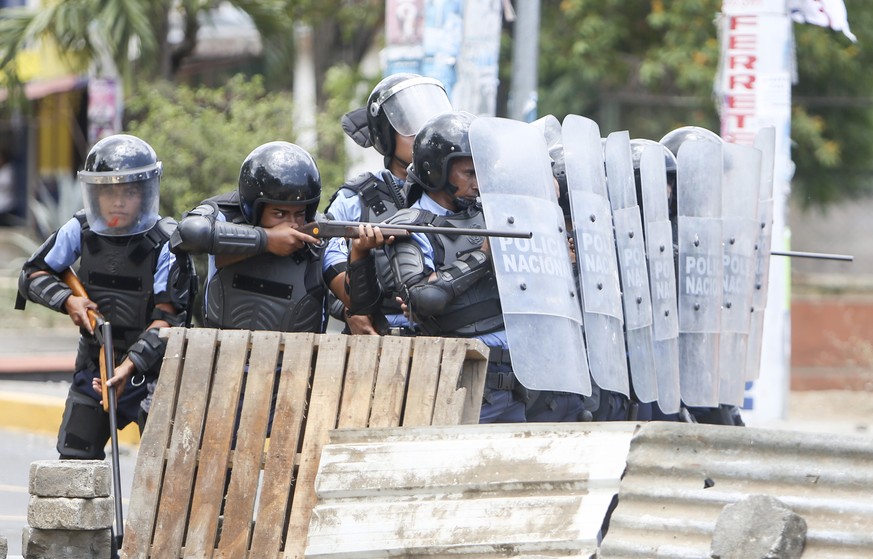 Riot police charge a barricade during clashes with demosntrators in Managua, Nicaragua, Friday, April 20, 2018. Police in Nicaragua say that a police officer, protester, and pro-government activist ha ...