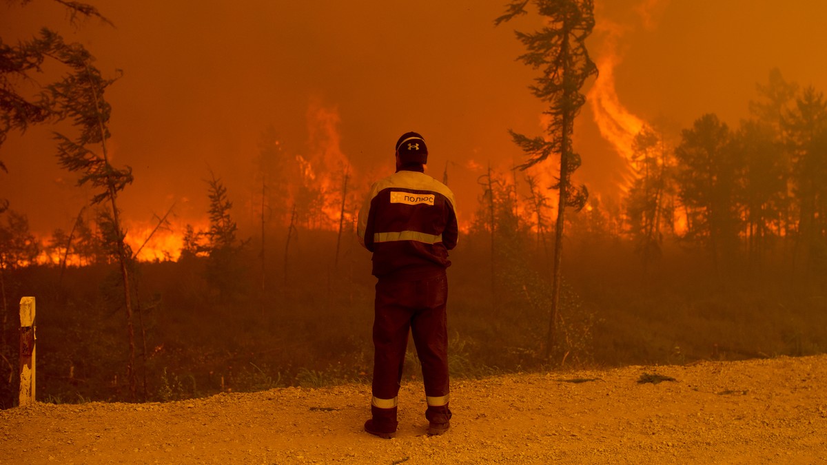 A firefighter stands at the scene of forest fire near Kyuyorelyakh village at Gorny Ulus area west of Yakutsk, in Russia, Saturday, Aug. 7, 2021. Wildfires in Russia's vast Siberia region endange ...
