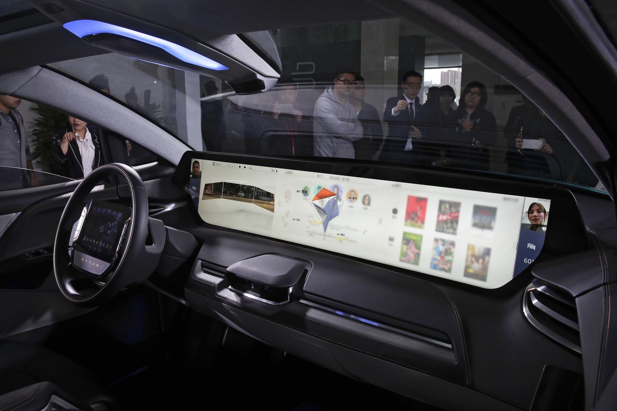 Invited guests and journalists are seen through the windshield of a BYTON electric concept car on display during a test drive event ahead of the Auto China 2018 automotive exhibition in Beijing, Sunda ...
