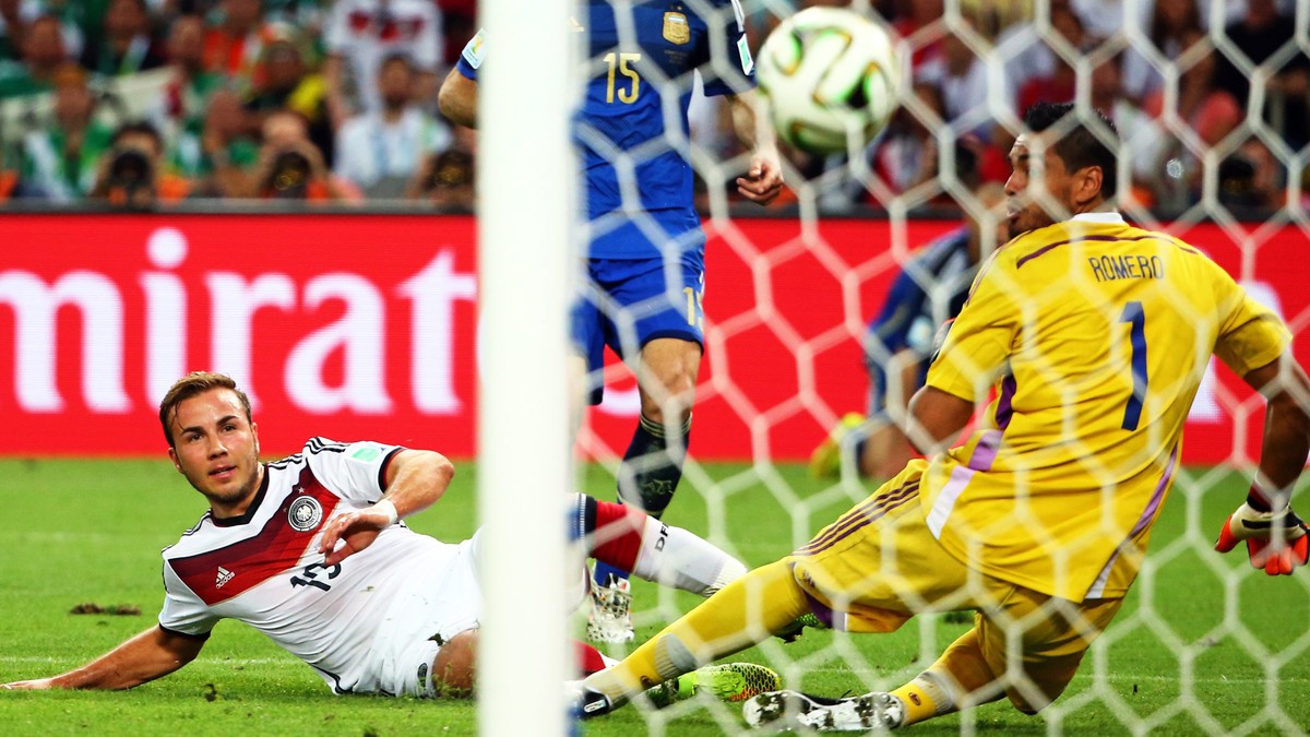 epaselect epa04314782 Germany's Mario Goetze (L) scores the 1-0 past Argentina's goalkeeper Sergio Romero (R) during the FIFA World Cup 2014 final between Germany and Argentina at the Estadi ...