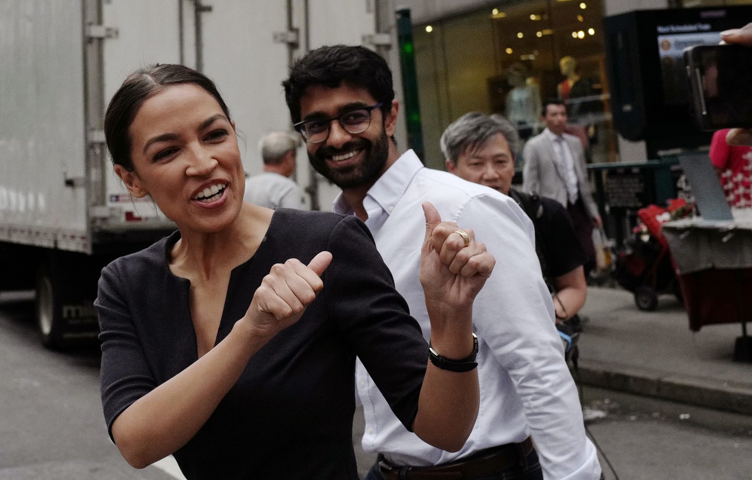 Alexandria Ocasio-Cortez, the winner of a Democratic Congressional primary in New York, greets a passerby in New York, Wednesday, June 27, 2018, the morning after she upset U.S. Rep. Joe Crowley in Tu ...