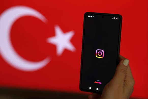 epa11521392 A woman holds a phone showing the Instagram logo, in Istanbul, Turkey, 03 August 2024. A nationwide block to access Instagram was implemented on 02 August, Turkey?s Information and Communi ...