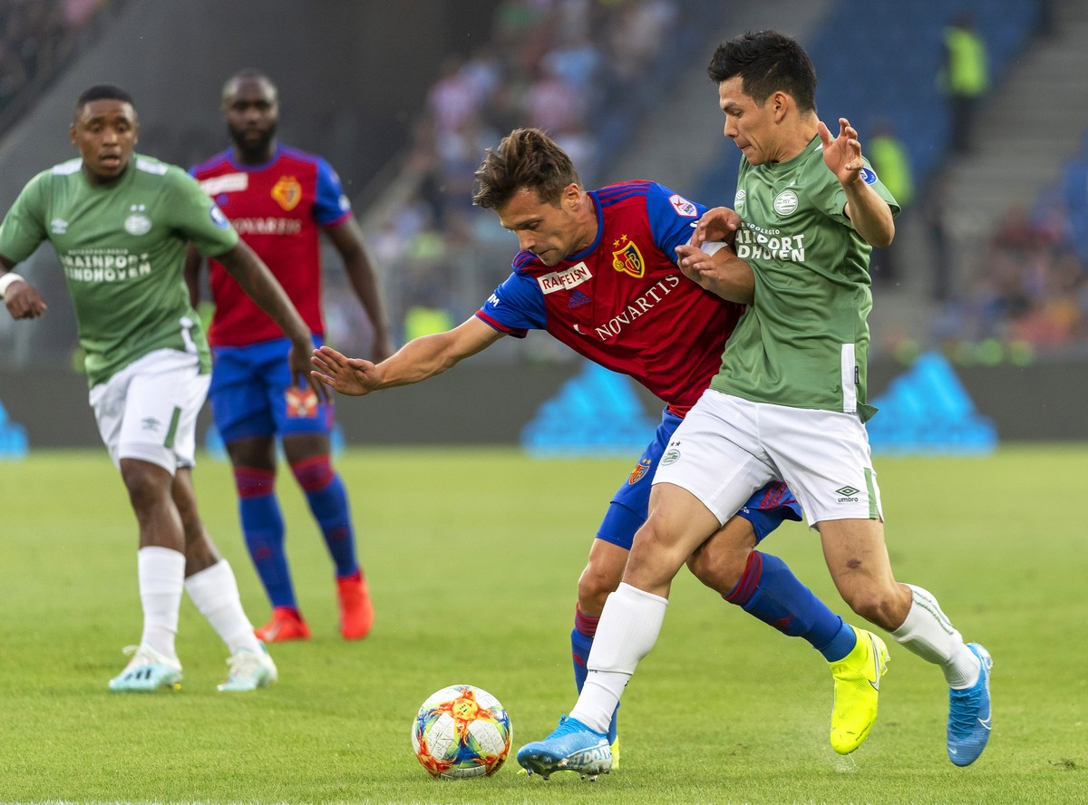 epa07748923 Basel's Valentin Stocker (C) in action against PSV Eindhoven's Hirving Lozano (R) during the UEFA Champions League second qualifying round, second leg soccer match between FC Bas ...