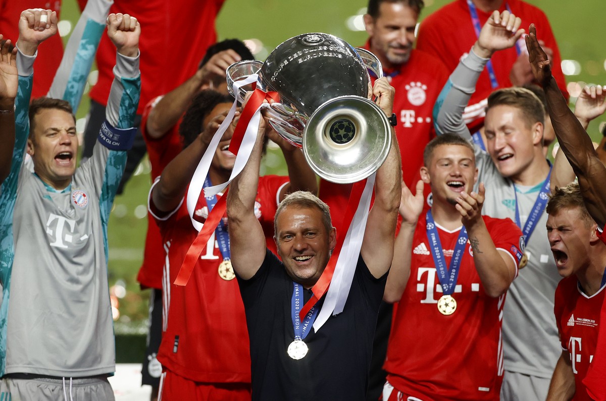 Bayern's head coach Hans-Dieter Flick lifts the trophy after Munich won the Champions League final soccer match between Paris Saint-Germain and Bayern Munich at the Luz stadium in Lisbon, Portuga ...