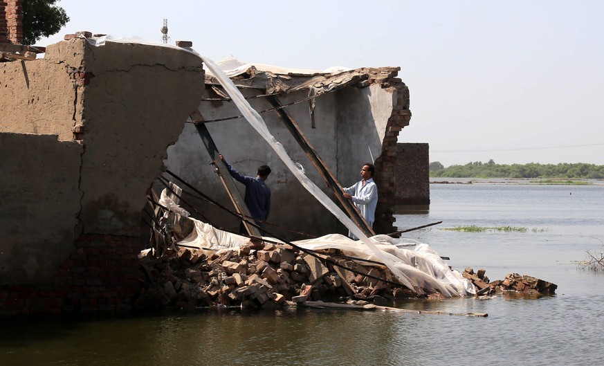 epa10156880 People check the damage to their houses in the aftermath of floods in Tando Hyder, Sindh province, Pakistan, 03 September 2022. According to the National Disaster Management Authority (NDM ...