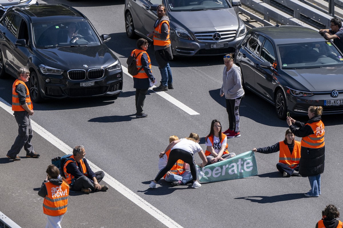 Aktivisten von "Renovate Switzerland" protestieren vor dem Gotthard Tunnel bei Goeschenen im Kanton Uri, weahrend dem sich der Auffahrt Reiseverkehr vor dem Gotthard Nordportal auf mehrere K ...