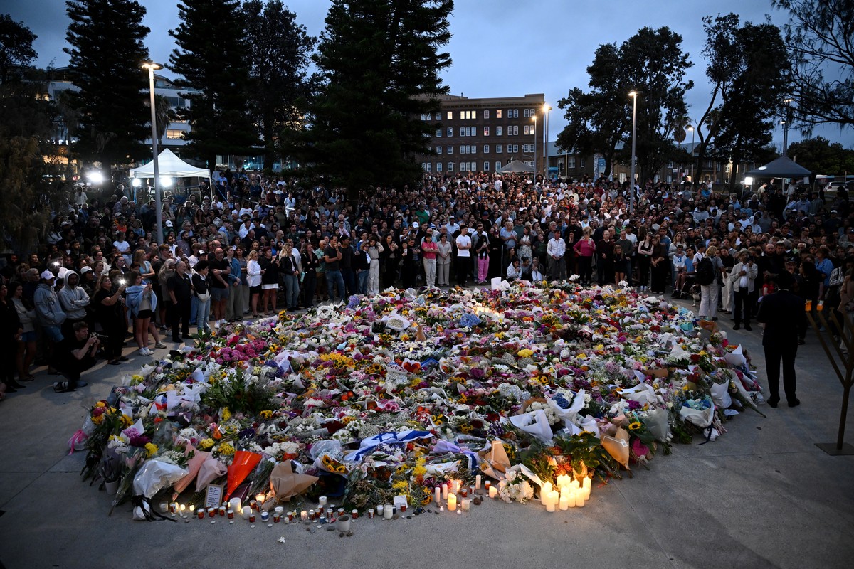 epa12593512 Mourners attend a vigil at a memorial at Bondi Beach in Sydney, Australia, 15 December 2025. Australia is in mourning after gunmen opened fire on Bondi Beach, killing at least 15 people in ...