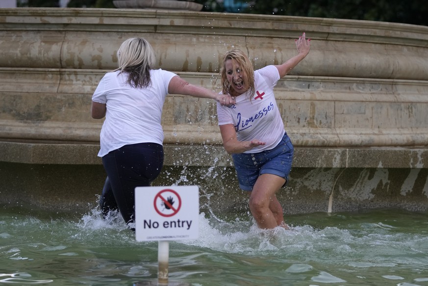 England supporters celebrate in a fountain in Trafalgar Square after watching their team win the final of the Women&#039;s Euro 2022 soccer match between England and Germany being played at Wembley st ...
