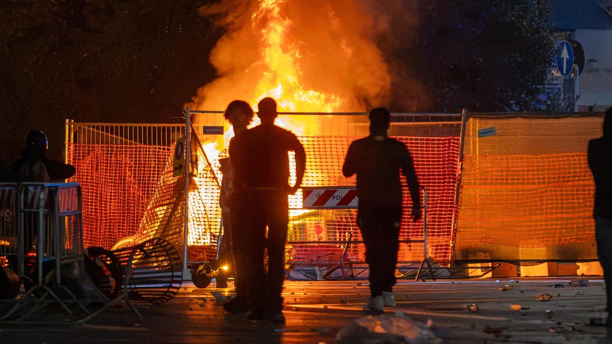 A fire burns following clashes between police and "Italia in Piazza" protesters in front of the Milan Cathedral in Milan, Italy, on Saturday, Oct. 17, 2026. (Stefano Porta/LaPresse via AP) = ...