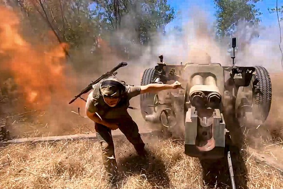 In this photo taken from a video released by the Russian Defense Ministry on Thursday, Aug. 22, 2024, a Russian soldier fires from D-30 howitzer towards Ukrainian positions in an undisclosed location  ...