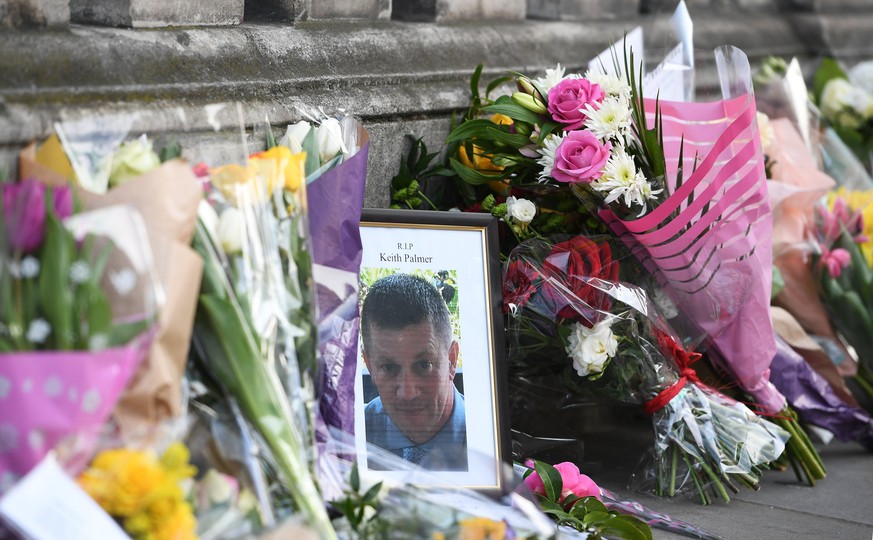 epa05866383 A picture of British policeman Keith Palmer is seen among flowers near the Houses of Parliament following the 22 March incidents in central London, Britain, 23 March 2017. Scotland Yard sa ...