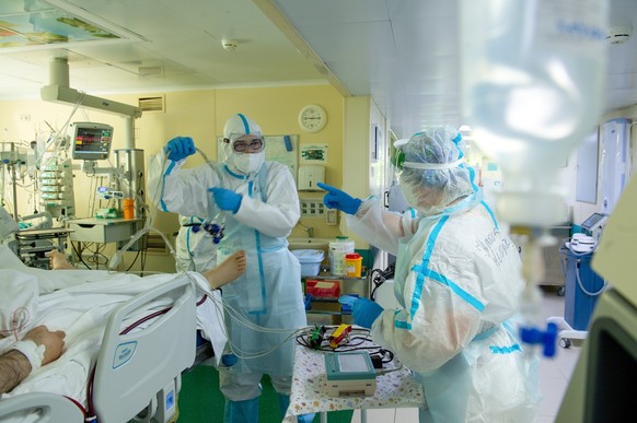 Medics wearing special suits to protect against coronavirus prepare to treat a patient with coronavirus at the City hospital No. 52 for coronavirus patients in Moscow, Russia, Thursday, June 17, 2021. ...