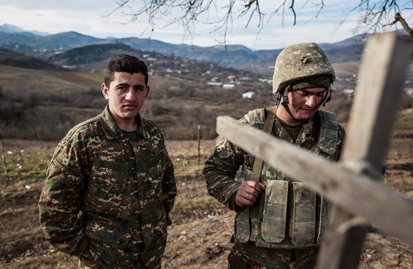 epa09033340 (10/27) Hamlet (R) and his soldier comrade stand next to a trench near Martuni, an eastern city of Nagorno-Karabakh, 16 January 2021. The two soldiers continue their duty weeks after the e ...