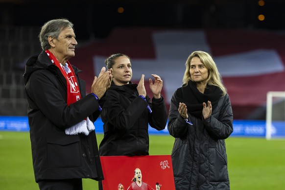 Switzerland&#039;s Fabienne Humm, center, get honored and officially retired from the Swiss national team by Switzerland&#039;s soccer federation president Dominique Blanc, left, and Marion Daube, Dir ...