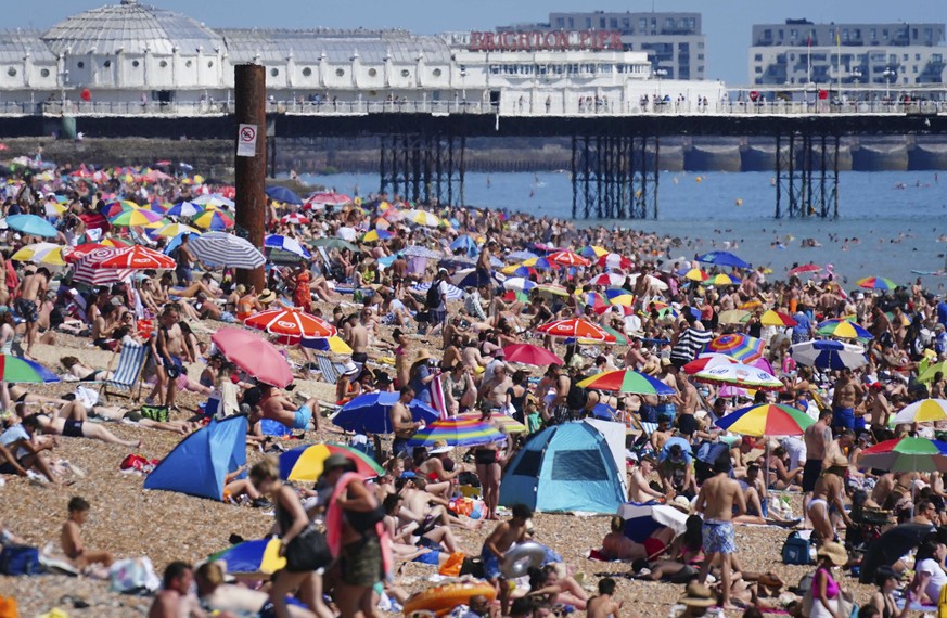 People gather on the beach during hot weather at Brighton, southern England, Sunday July 18, 2021. The hottest day of the year so far was recorded across the whole UK on Saturday, and forecasters pred ...