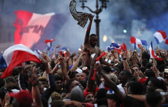 People react outside the Paris town hall after France defeated Belgium in the World Cup semifinal match between France and Belgium, Tuesday, July 10, 2018 in Paris. France advanced to the World Cup fi ...