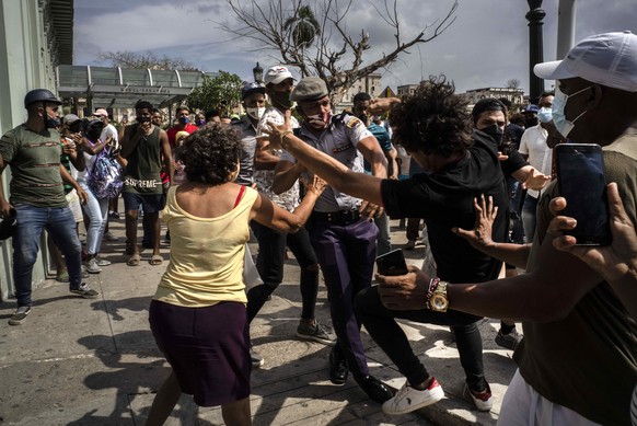 FILE - In this July 11, 2021 file photo, police scuffle and detain an anti-government demonstrator during a protest in Havana, Cuba. A month after the largest protest in years hit Cuba, the government ...