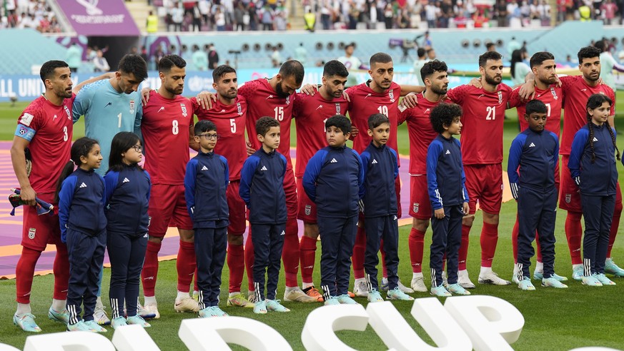 The team of Iran standing on the pitch waiting for the national anthem prior to the the World Cup group B soccer match between England and Iran at the Khalifa International Stadium, in Doha, Qatar, Mo ...