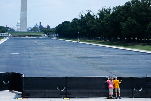 Individuals peek over the fence to see the drained Lincoln Memorial Reflecting Pool,, Monday, July 27, 2026, in Washington. (AP Photo/Allison Robbert)
APTOPIX Lincoln Memorial Reflecting Pool