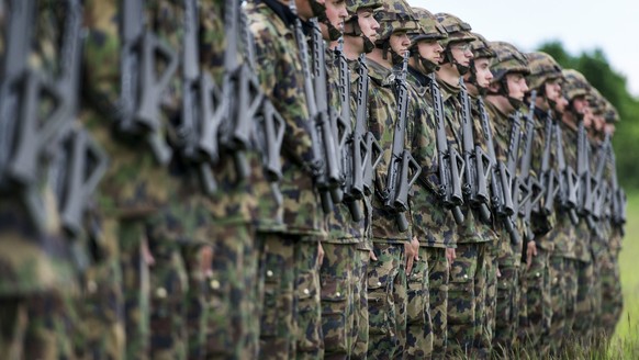 Infantry recruits stand in a row on a green field, pictured on May 17, 2013, in the infantry recruit school of the Swiss army in Colombier, canton of Neuchatel, Switzerland. (KEYSTONE/Christian Beutle ...