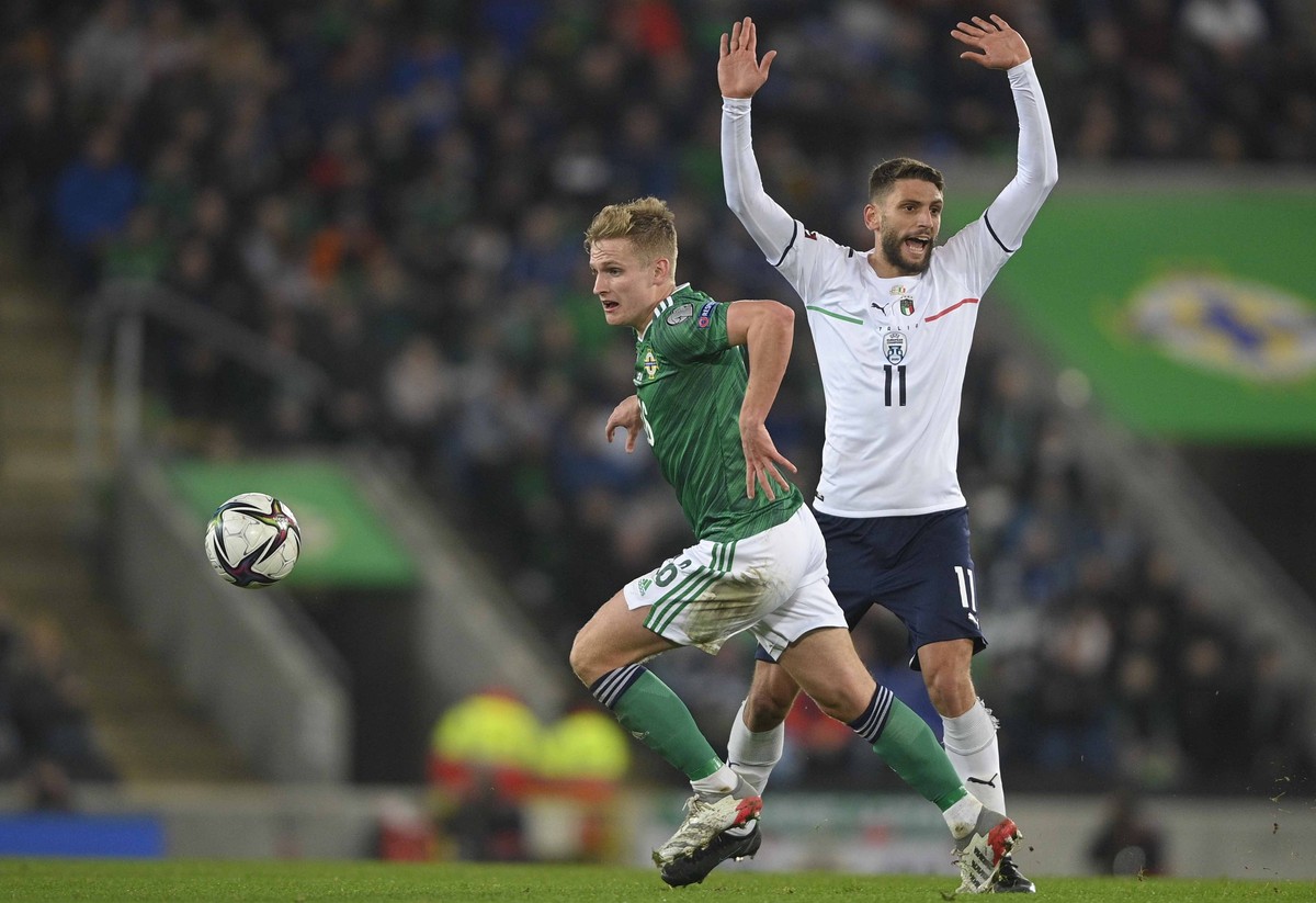 epa09584175 Northern Ireland's Alistair Mccann (L) in action against Italy?s Domenico Berardi (R) during the FIFA World Cup 2022 group C qualifying soccer match between Northern Ireland and Italy ...
