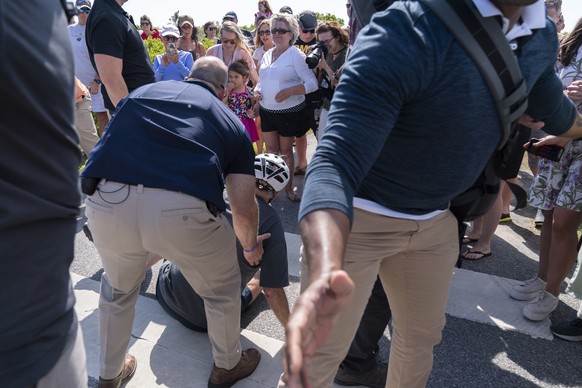 President Joe Biden is helped by U.S. Secret Service agents after he fell trying to get off his bike to greet a crowd on a trail at Gordons Pond in Rehoboth Beach, Del., Saturday, June 18, 2022. (AP P ...