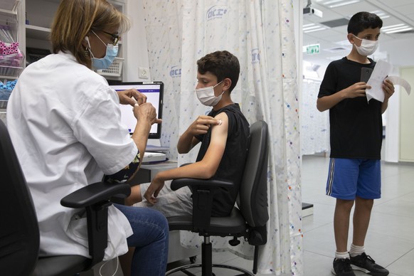 An Israeli youth receives a Pfizer-BioNTech COVID-19 vaccine in the central Israeli city of Rishon LeZion, Sunday, June 6, 2021. Israel started vaccinating children from 12 to 15 on Sunday. (AP Photo/ ...