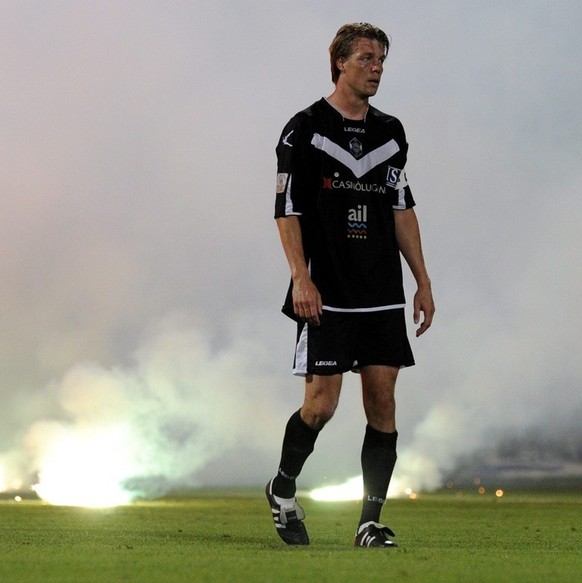 Leuchtpetarden brennen auf dem Spielfeld hinter Luganos Captain Philippe Montandon, am Samstag 21. Mai 2011, nach dem Fussball Challenge League Meisterschaftsspiel zwischen dem FC Lugano und FC Wohlen ...