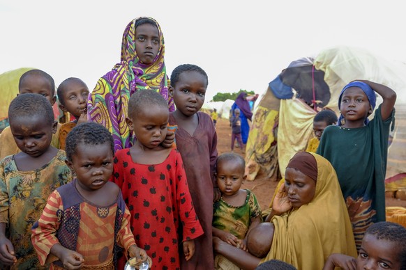 A mother and children displaced by drought sit outside their makeshift shelter on the outskirts of Baidoa, in Somalia Saturday, Oct. 29, 2022. Ships loaded with grain departed Ukraine on Tuesday, Nov. ...