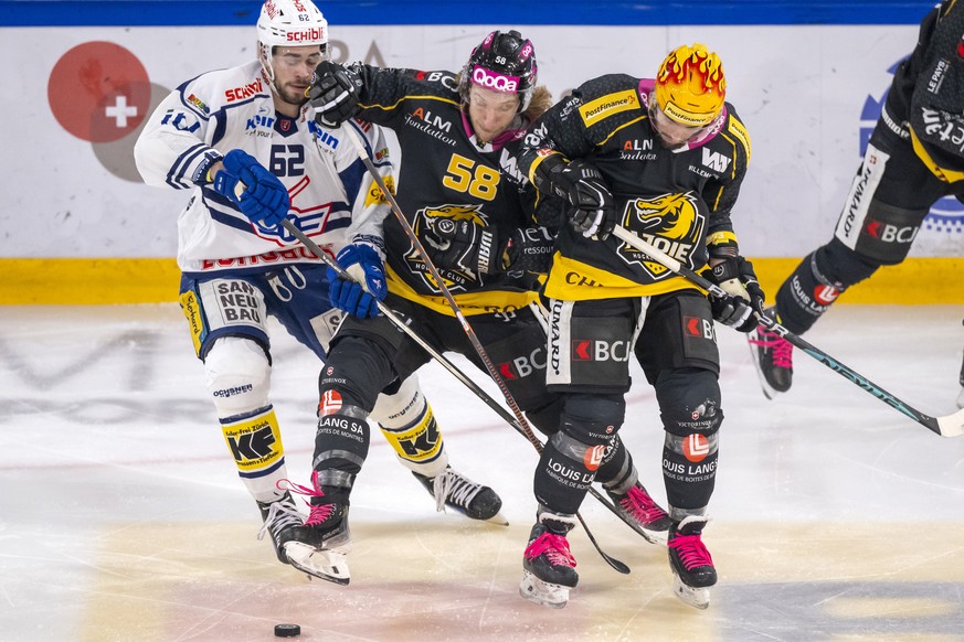 Klotens Harrison Schreiber gegen Ajoies Jesse Zgraggen und PostFinance Top Scorer Daniel Audette, von links, im Eishockey-Qualifikationsspiel der National League zwischen dem HC Ajoie und dem EHC Klot ...