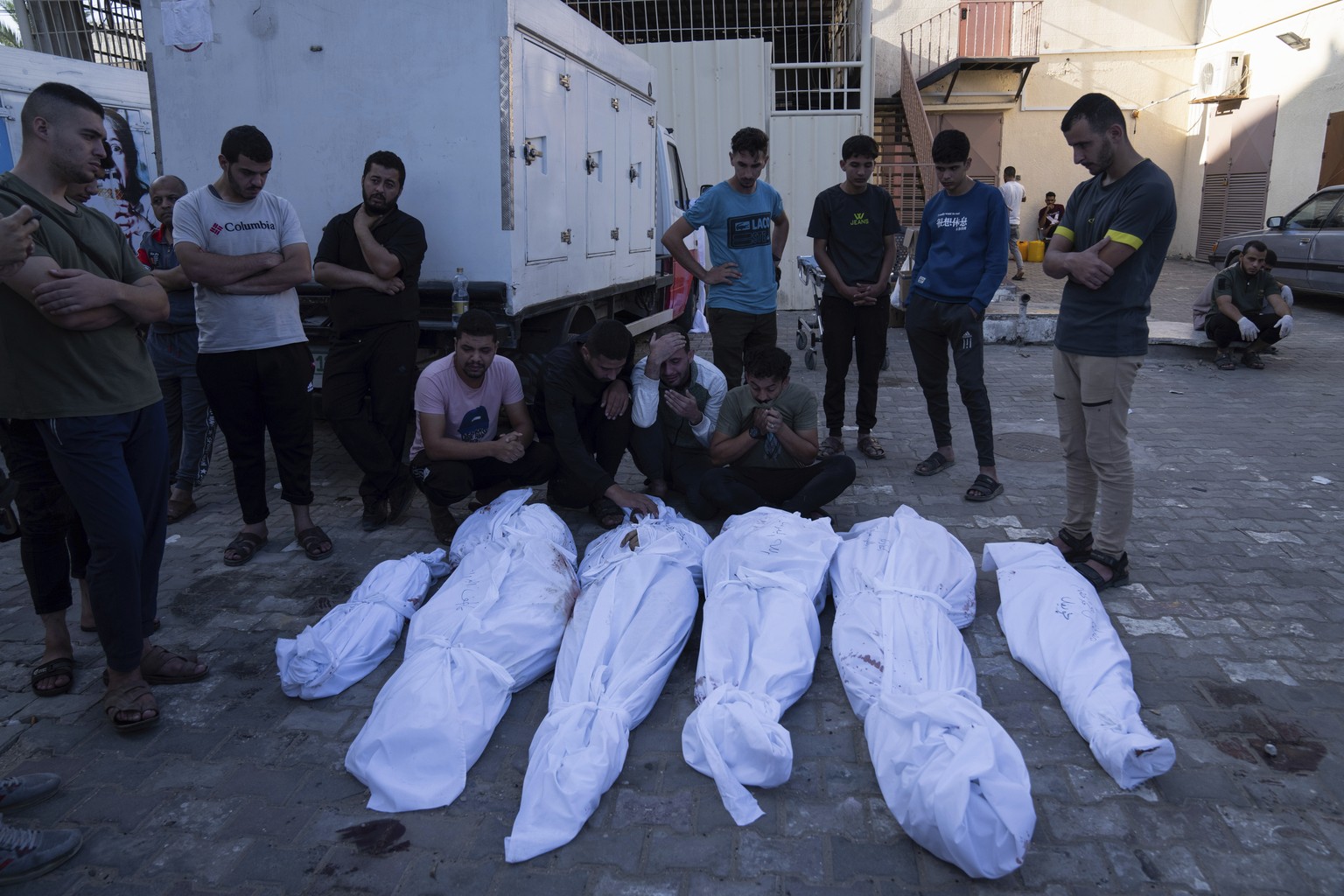 Palestinians mourn relatives killed in the Israeli bombardment of the Gaza Strip, in front of the morgue in Deir al Balah, Tuesday, Oct. 31, 2023. ( AP Photo/Fatima Shbair)