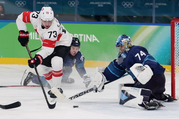 epa12755398 Sandro Schmid of Switzerland (L) in action against goalkeeper Juuse Saros of Finland (R) during the Men's Ice Hockey quarterfinal match between Finland and Switzerland at the Milano C ...